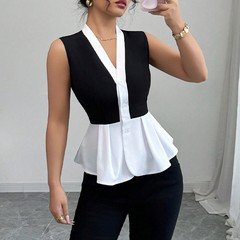 Lifestyle front view of the black and white contrast-trim v-neck peplum top, showing its silhouette and design details.