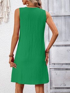 Back view of the green notch-neck sleeveless shift dress, showing its silhouette and design details.