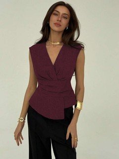 Full-length front view of the burgundy v-neck asymmetric wrap top, showing its silhouette and design details.
