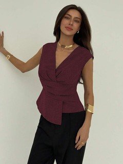 Lifestyle front view of the burgundy v-neck asymmetric wrap top, showing its silhouette and design details.