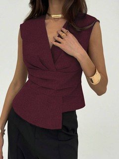 Styled front view of the burgundy v-neck asymmetric wrap top, showing its silhouette and design details.
