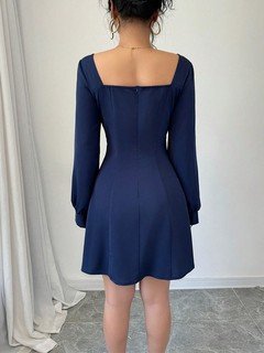 Back view of the navy square-neck bishop-sleeve dress, showing its silhouette and design details.