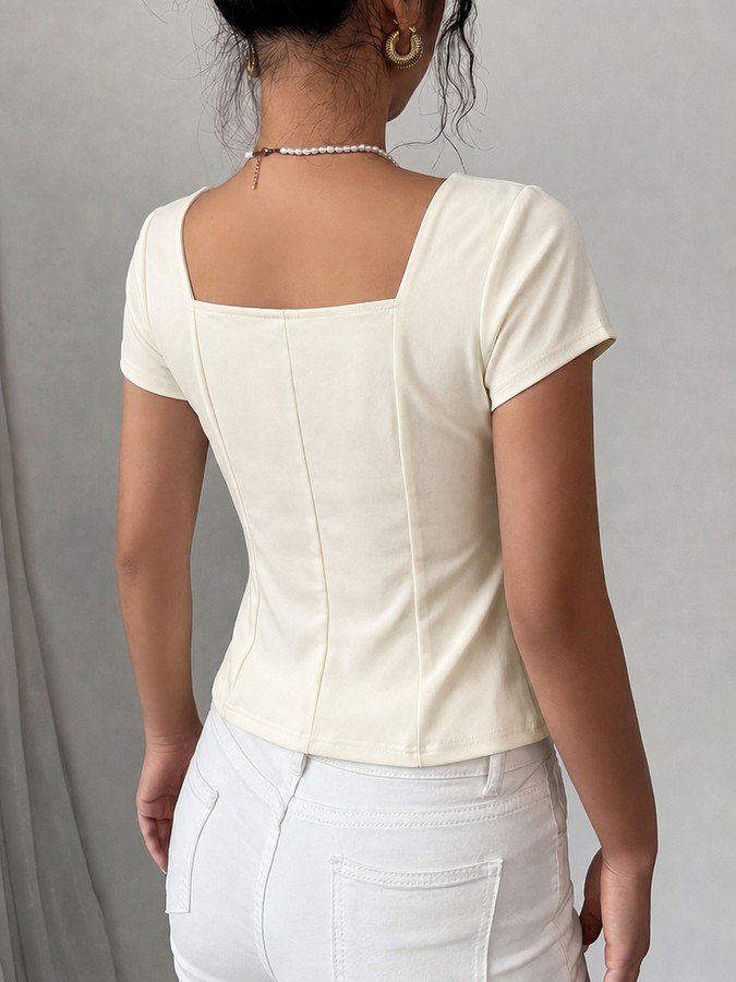 Back view of the ivory square-neck button-front short-sleeve top, showing the silhouette and fit.