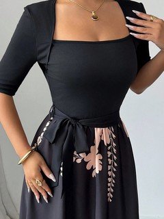 Neckline detail of the black square-neck floral-hem three-quarter-sleeve maxi dress, showing square neckline, floral border skirt and tie waist.