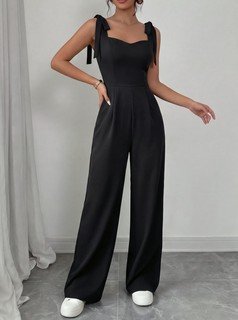 Angled front view of the black square-neck tie-strap wide-leg jumpsuit, showing the silhouette and fit.