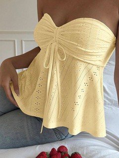 Close-up of the yellow sweetheart textured peplum top, showing its silhouette and design details.