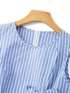 Bow waist detail of the blue striped bow-waist sleeveless fit-and-flare mini dress, showing vertical stripes, bow waist and flared mini skirt.