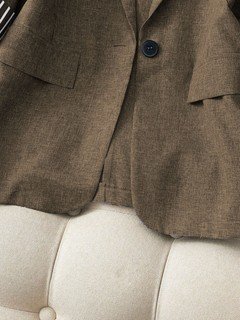 Button detail of the brown striped-cuff three-quarter-sleeve tailored blazer, showing rolled striped cuffs, notched lapels and tailored fit.