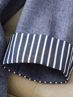 Striped cuff detail of the gray striped-cuff three-quarter-sleeve tailored blazer, showing rolled striped cuffs, notched lapels and tailored fit.