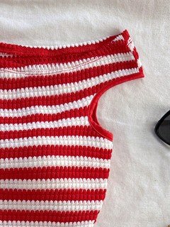 Construction detail of the red and white striped knit top and shorts set, showing the garment finish.