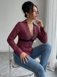 Seated front view of the burgundy striped lace-trim v-neck long-sleeve top, showing the silhouette and fit.