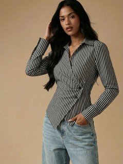 Angled front view of the black and white striped asymmetric wrap shirt, showing its silhouette and design details.