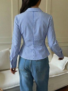 Back view of the blue striped asymmetric wrap shirt, showing its silhouette and design details.