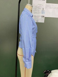 Mannequin view of the blue striped asymmetric wrap shirt, showing the garment shape and construction.