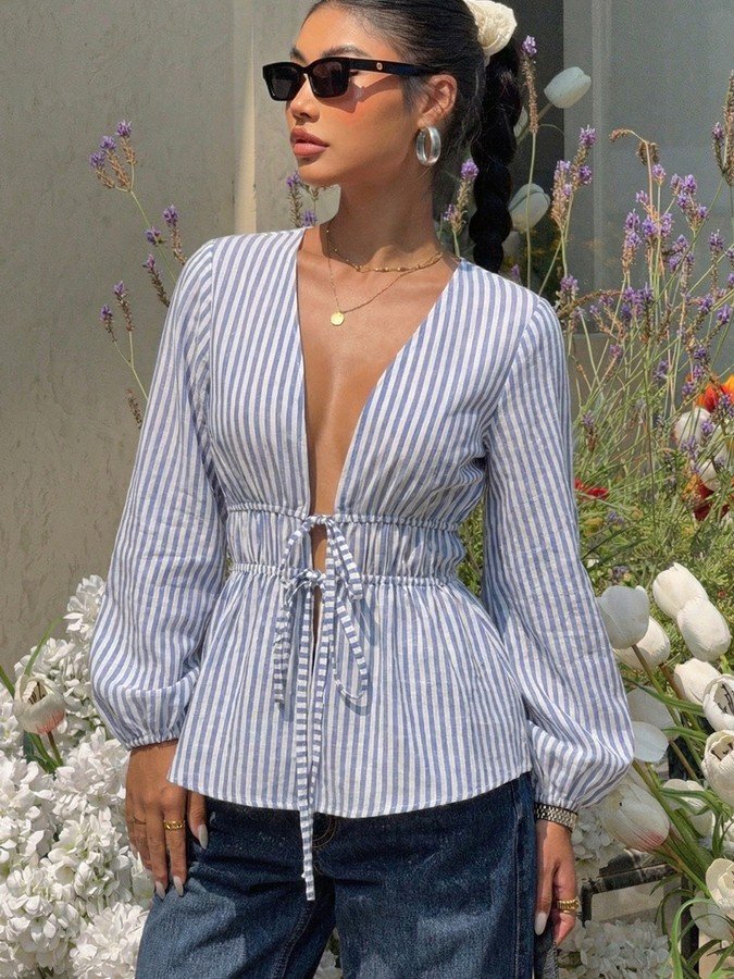 Front view of the blue and white striped tie-front peplum blouse, showing its silhouette and design details.