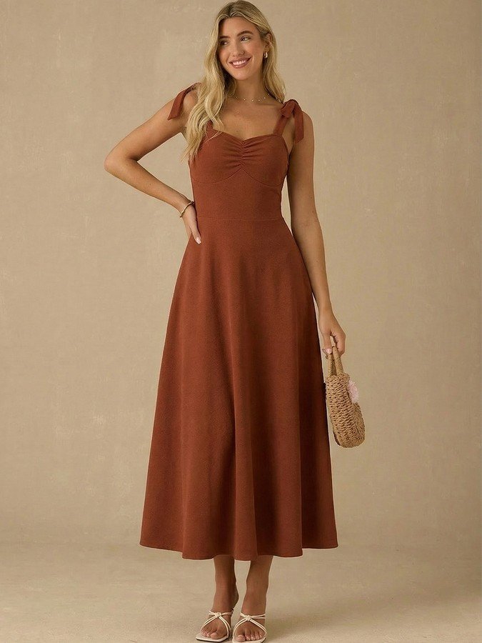 Front view of the rust sweetheart tie-strap midi dress, showing its silhouette and design details.