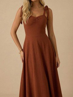 Angled front view of the rust sweetheart tie-strap midi dress, showing its silhouette and design details.