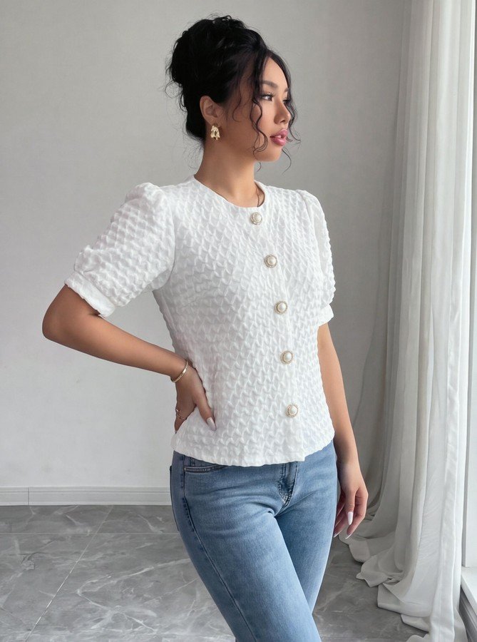 Side view of the white textured button-front short-sleeve blouse, showing the silhouette and fit.
