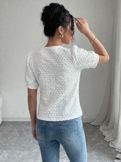 Back view of the white textured button-front short-sleeve blouse, showing the silhouette and fit.
