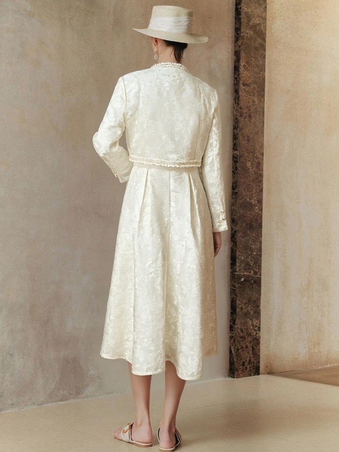 Back view of the cream textured jacket and dress set, showing its silhouette and design details.