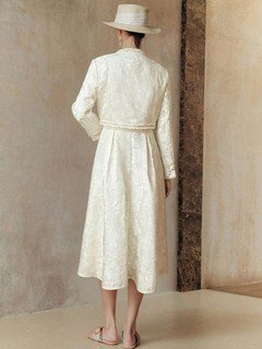Back view of the cream textured jacket and dress set, showing its silhouette and design details.