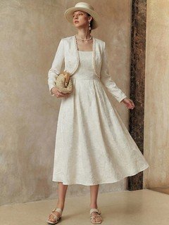 Full-length front view of the cream textured jacket and dress set, showing its silhouette and design details.