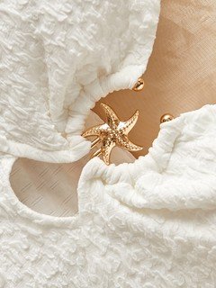 Construction detail of the white starfish halter cutout dress, showing the garment finish.