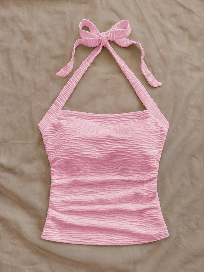 Flat-lay view of the pink textured tie-halter tank top, showing the garment shape and finish.