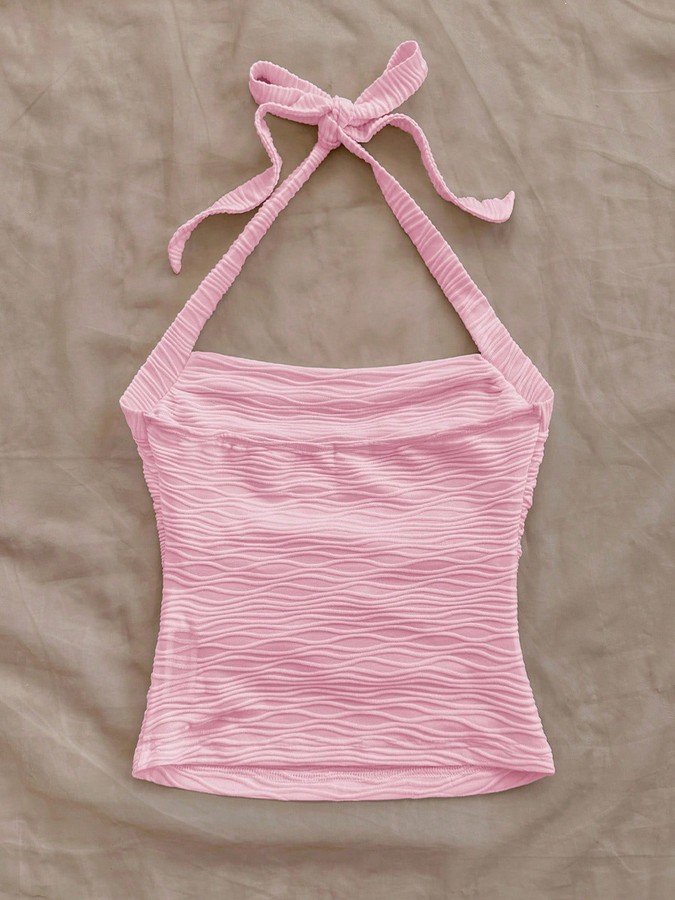 Flat-lay view of the pink textured tie-halter tank top, showing the garment shape and finish.