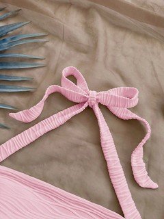 Construction detail of the pink textured tie-halter tank top, showing the garment finish.