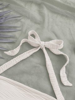 Construction detail of the white textured tie-halter tank top, showing the garment finish.