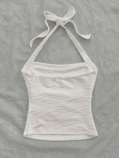 Flat-lay view of the white textured tie-halter tank top, showing the garment shape and finish.
