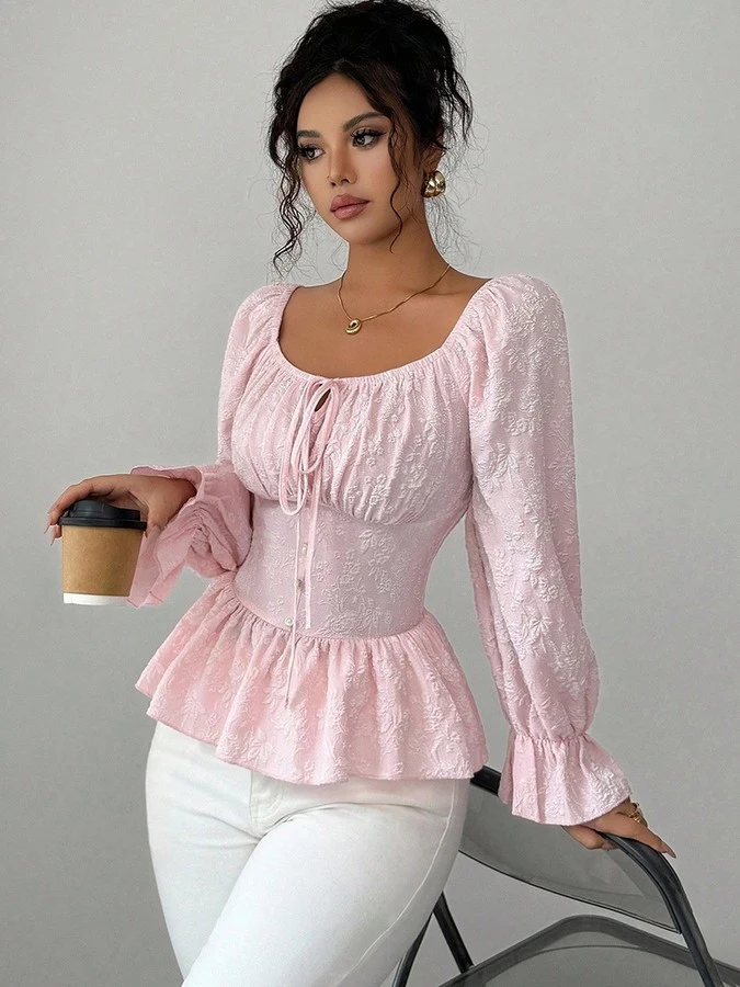 Front view of the pink tie-neck corset peplum blouse, showing its silhouette and design details.