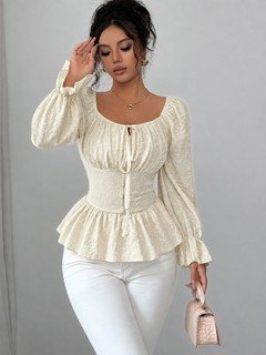 Angled front view of the cream tie-neck corset peplum blouse, showing its silhouette and design details.