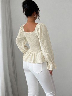 Back view of the cream tie-neck corset peplum blouse, showing its silhouette and design details.
