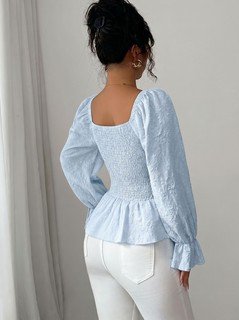 Back view of the light blue tie-neck corset peplum blouse, showing its silhouette and design details.