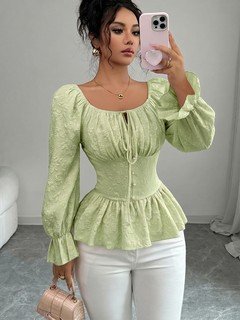Styled front view of the light green tie-neck corset peplum blouse, showing its silhouette and design details.