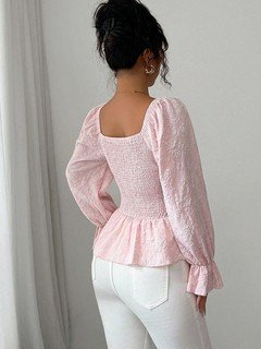 Back view of the pink tie-neck corset peplum blouse, showing its silhouette and design details.