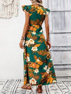 Back view of the green tropical floral high-low dress, showing its silhouette and design details.