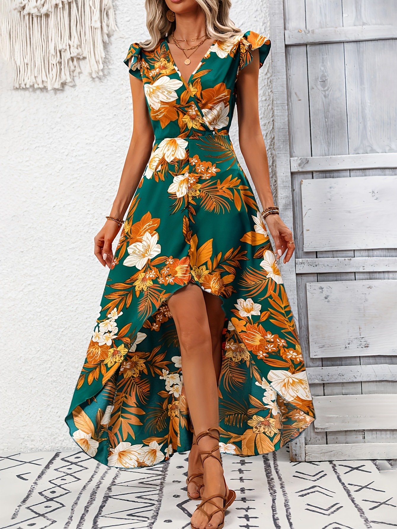 Front view of the green tropical floral high-low dress, showing its silhouette and design details.