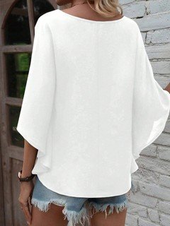 Back view of the white v-neck dolman-sleeve blouse, showing its silhouette and design details.