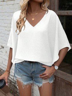 Full-length front view of the white v-neck dolman-sleeve blouse, showing its silhouette and design details.