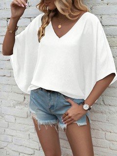 Lifestyle front view of the white v-neck dolman-sleeve blouse, showing its silhouette and design details.