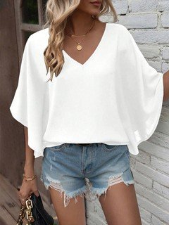 Styled front view of the white v-neck dolman-sleeve blouse, showing its silhouette and design details.