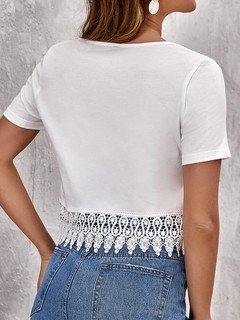 Back view of the white lace-hem v-neck crop top, showing its silhouette and design details.