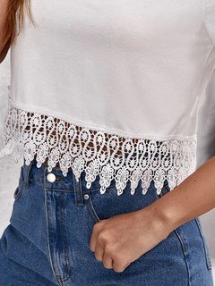 Construction detail of the white lace-hem v-neck crop top, showing the garment finish.