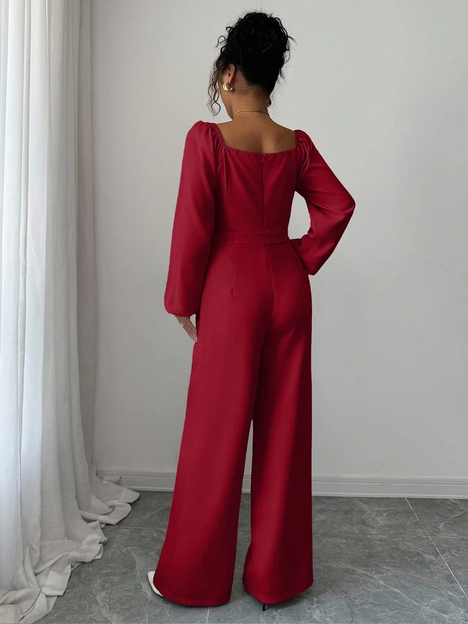 Back view of the red v-neck tie-waist long-sleeve wide-leg jumpsuit, showing the silhouette and fit.