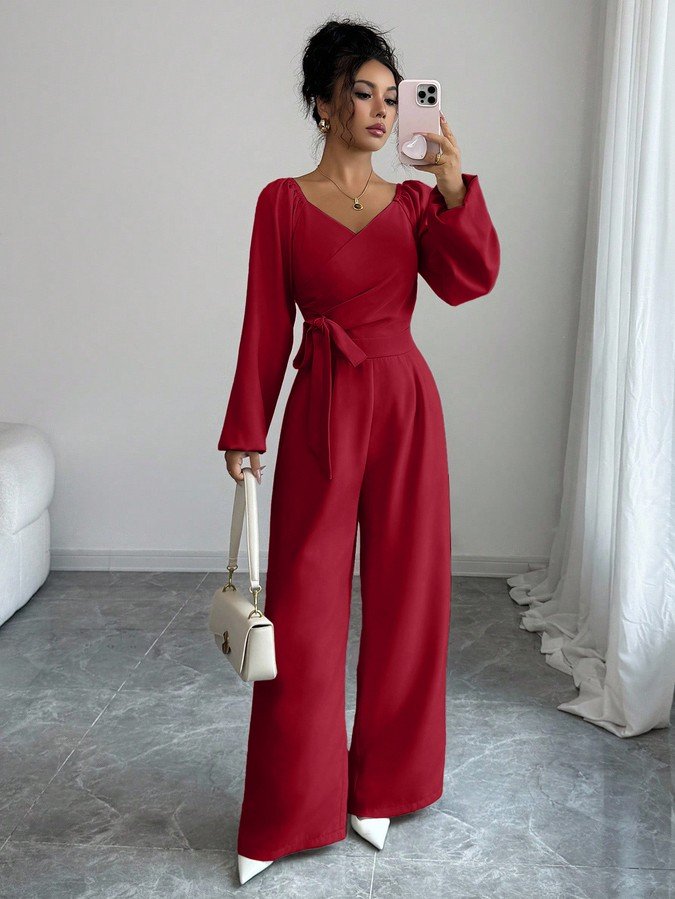 Front view of the red v-neck tie-waist long-sleeve wide-leg jumpsuit, showing the silhouette and fit.