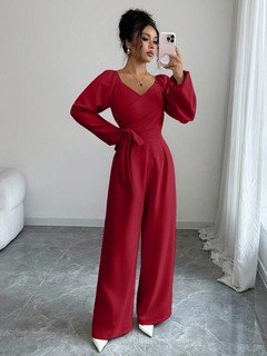 Angled front view of the red v-neck tie-waist long-sleeve wide-leg jumpsuit, showing the silhouette and fit.