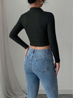 Back view of the black zip-front deep-v long-sleeve cropped top, showing the silhouette and fit.